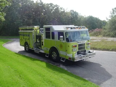 Front-left wide view of the lime pumper showing cab face and full side profile.