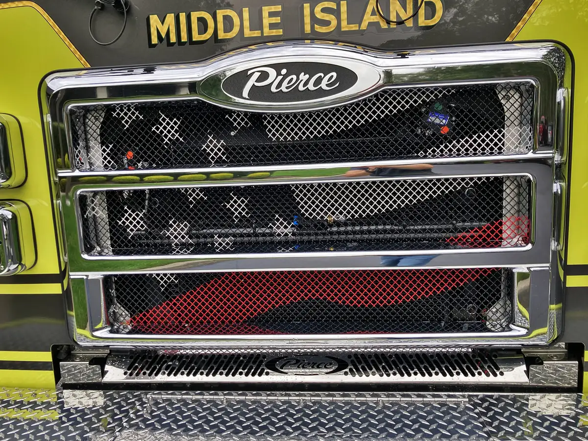 Head-on front view showing chrome grille, bumper intakes, and light bar