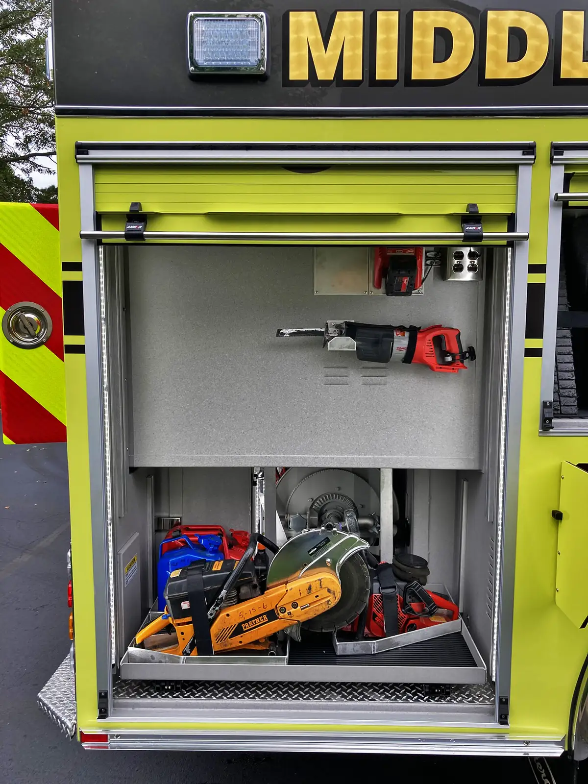 Rear-side compartment open showing gear bags and lower storage area