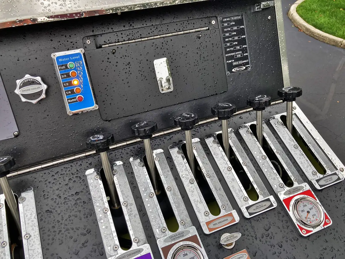 Side compartment close-up showing mounted long-handled tools and fittings