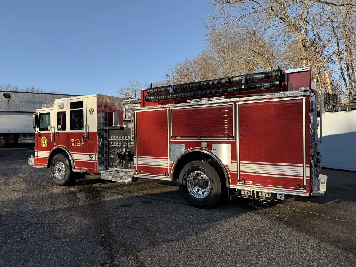 Driver-side profile view showing side compartments, rear wheel, and hosebed rail