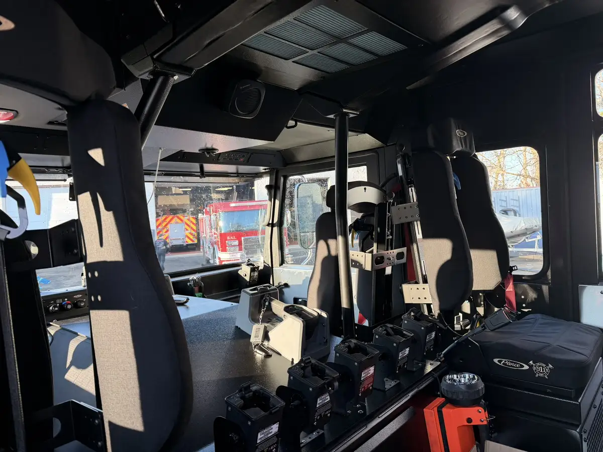 Crew cab interior view showing rear seats, red restraints, and center aisle