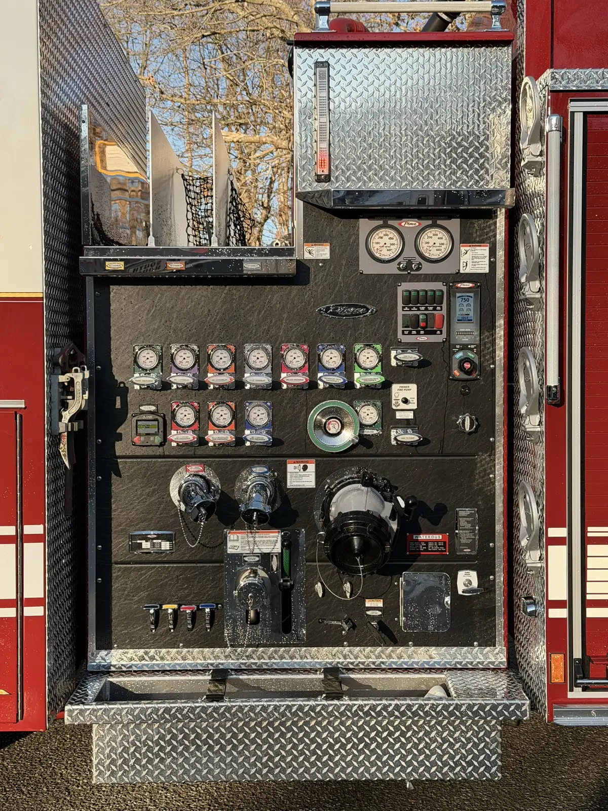 Pump panel close-up showing gauges, valve handles, and intake controls