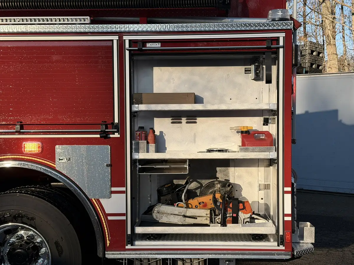 Open side compartment above rear wheel showing shelf divider and equipment space
