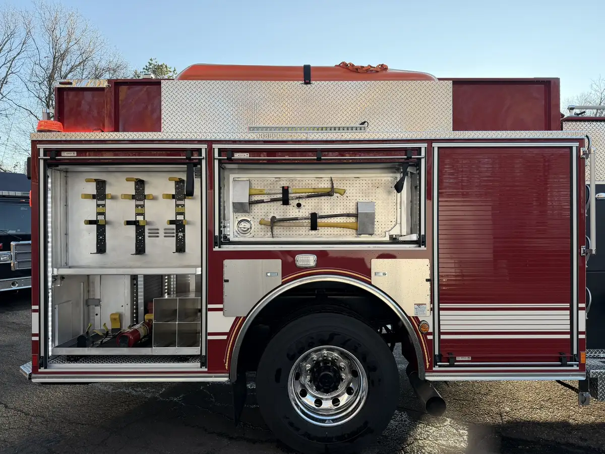 Officer-side full profile showing open equipment bays and rear wheel