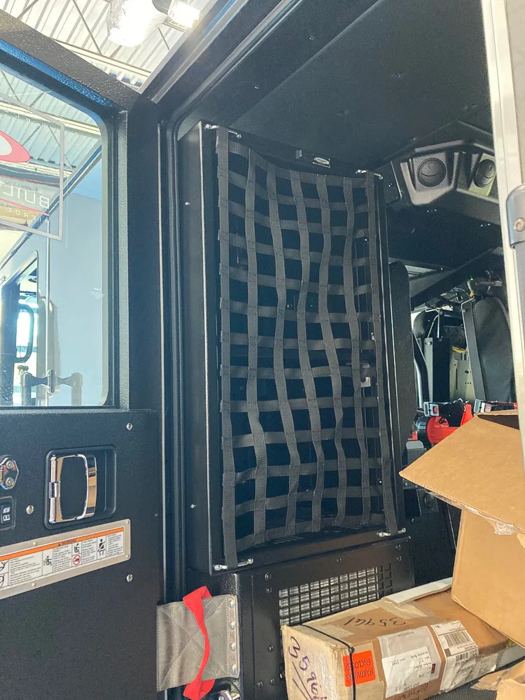 Cab rear area view showing mesh divider and storage boxes