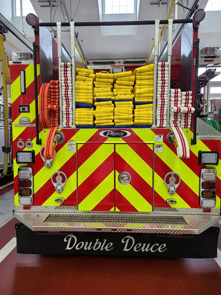 Rear view showing chevrons and hosebed loaded with yellow hose bundles