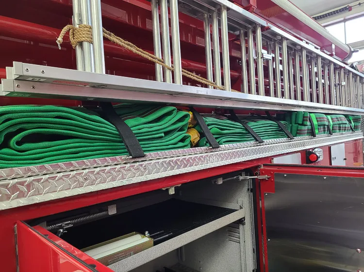 Open long side compartment showing coiled hose in horizontal rack