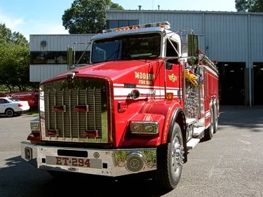 Head-on front view showing chrome grille, bumper lights, and hood contours