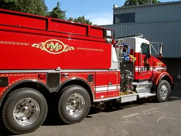 Driver-side mid-body close-up showing tandem wheel area and polished side compartments