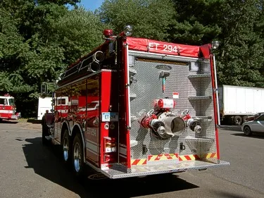 Rear-right exterior view showing rear pump connections and tailboard area