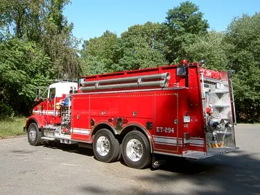 Rear-right profile showing tanker body, rear inlets, and tandem wheel layout