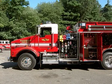 Driver-side pump panel view showing gauges, valves, and open side compartment