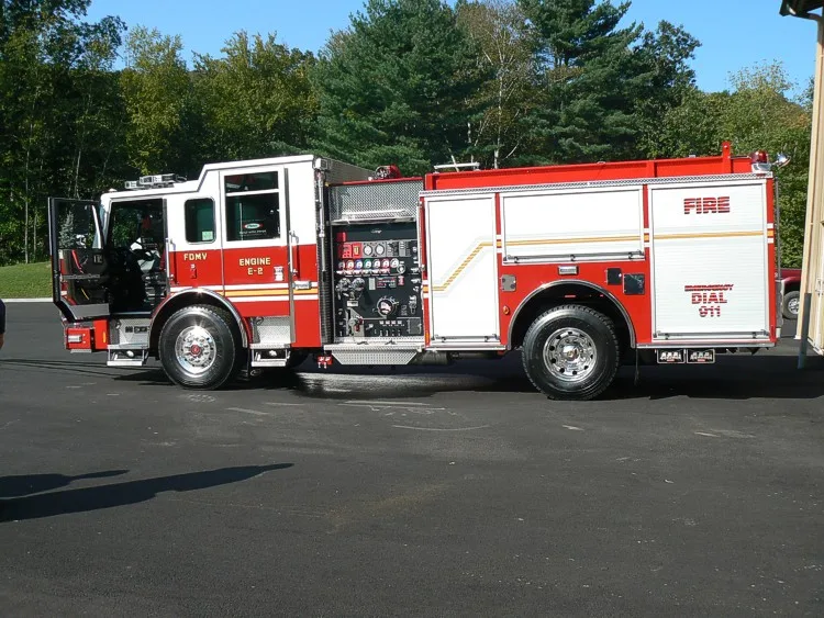 Driver-side profile of a pumper showing exposed pump panel controls and side compartments.