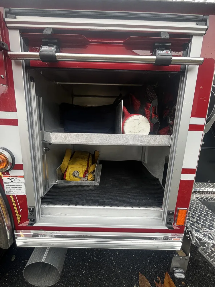 Open side compartment showing lower shelf and utility storage bay