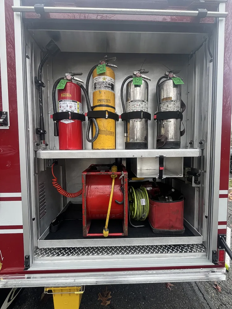 Open side compartment showing mounted extinguishers and equipment bins
