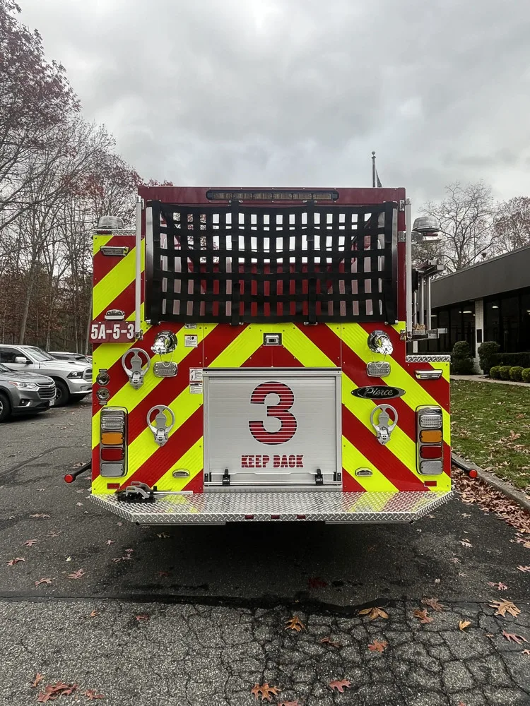 Rear view showing red-and-yellow chevrons and hosebed netting