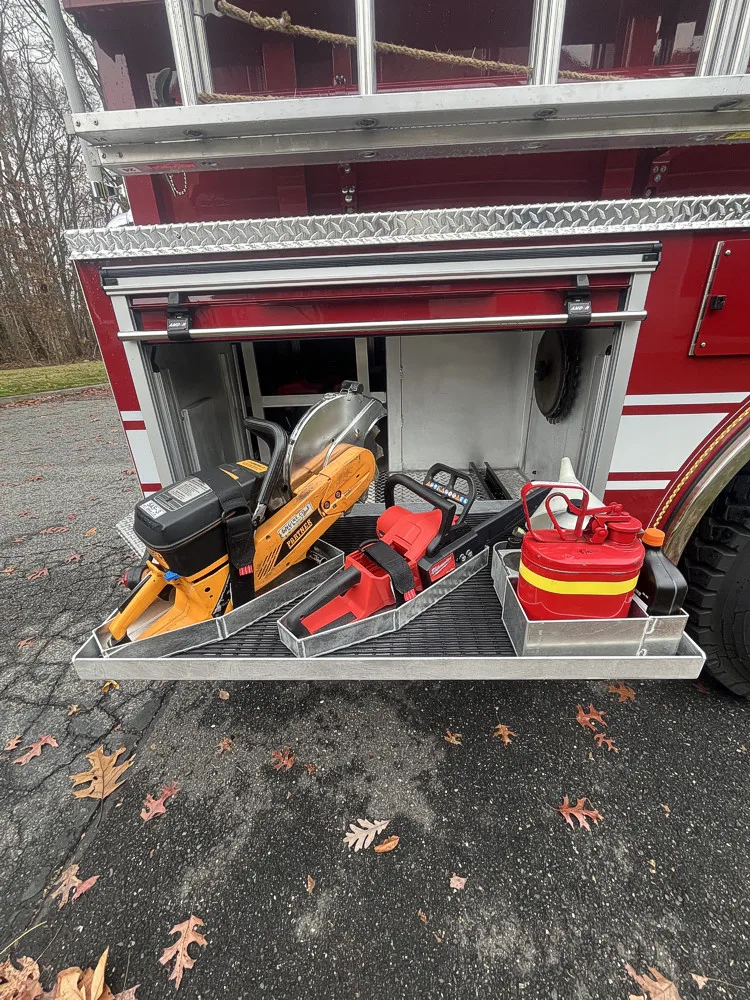 Open side compartment showing rescue tools and storage bags on tray