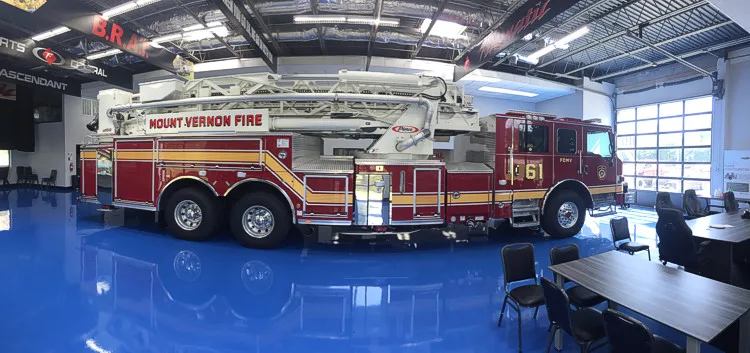 Full right-side profile showing ladder bed, rear body compartments, and tandem rear wheels.