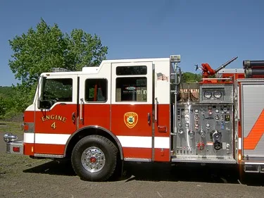 Driver-side cab and pump panel view showing gauges, valves, and wheel area