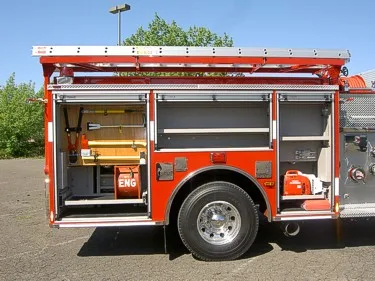 Passenger-side profile with open compartments showing tools and storage bays