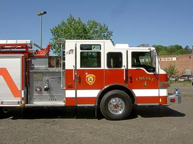 Driver-side profile showing cab, pump panel, and front wheel area