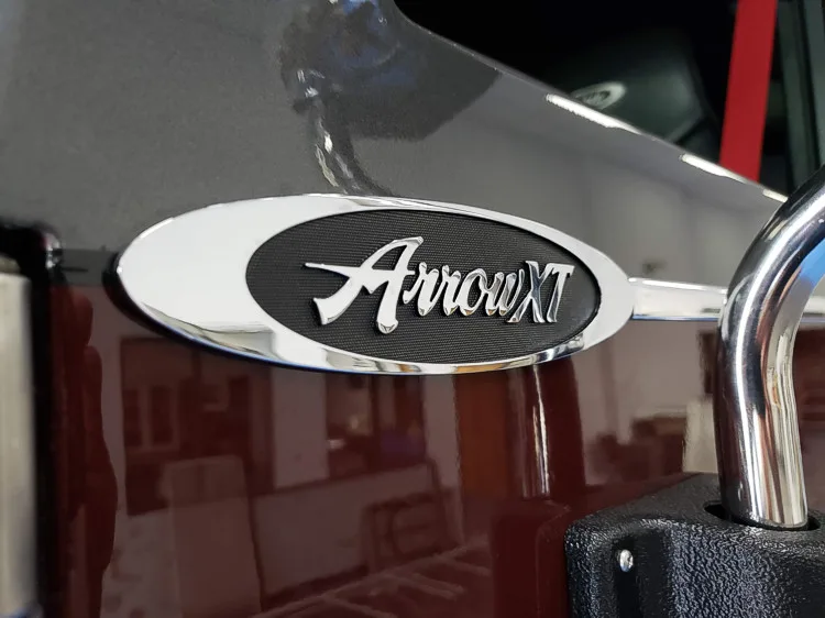 Body badge close-up showing Arrow XT emblem on dark panel