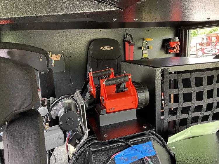 Cab interior side view showing rear seat and equipment storage bin