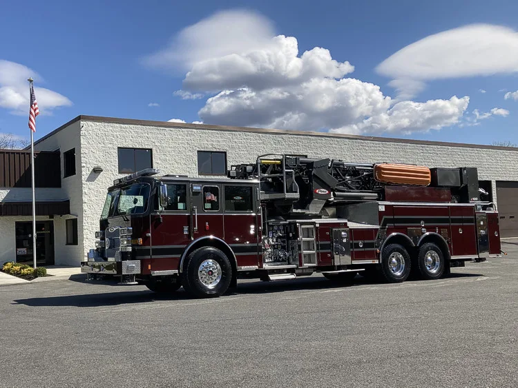 Driver-side full profile view showing ladder body and tandem axles