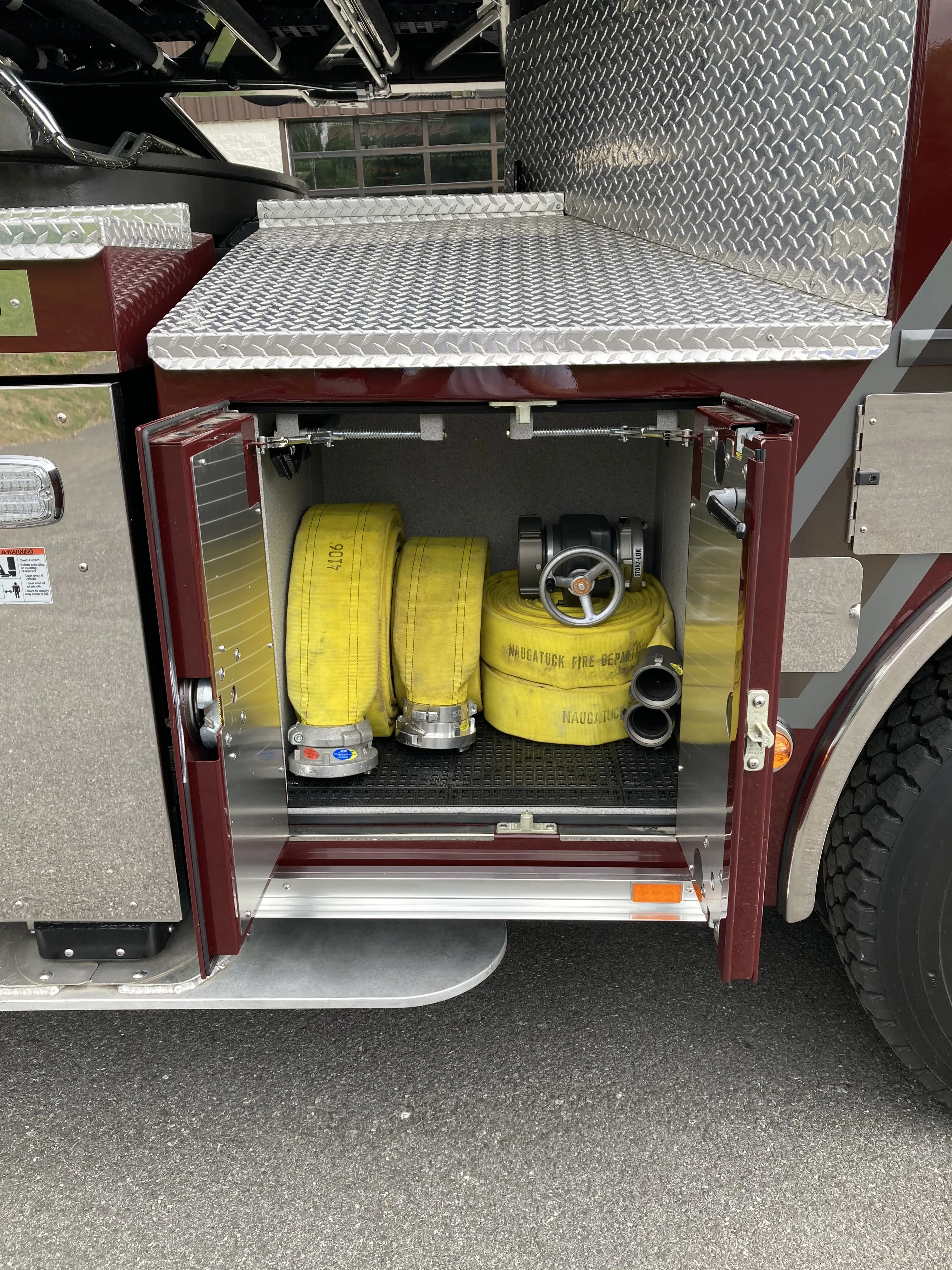 Open side compartment showing mounted yellow cylinders and tools