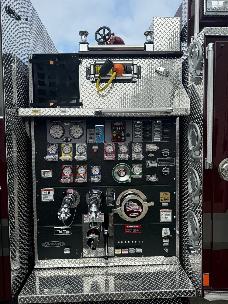 Pump panel close-up showing gauges, valves, intake connections, and control switches.