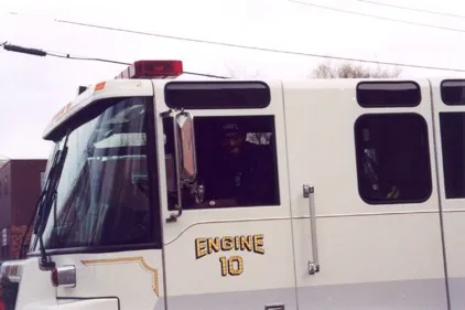 Close-up of the cab side showing officer window area, mirror, roof warning light, and unit number text.