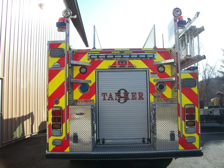 Straight rear view with red-yellow chevrons, rear fittings, and center rear roll-up door.
