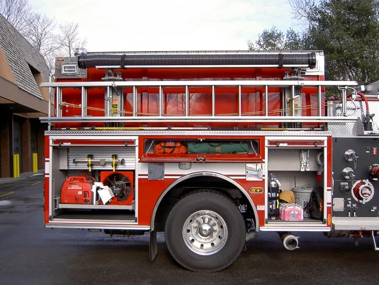Passenger-side mid-body view showing side hosebed rails and rear wheel area
