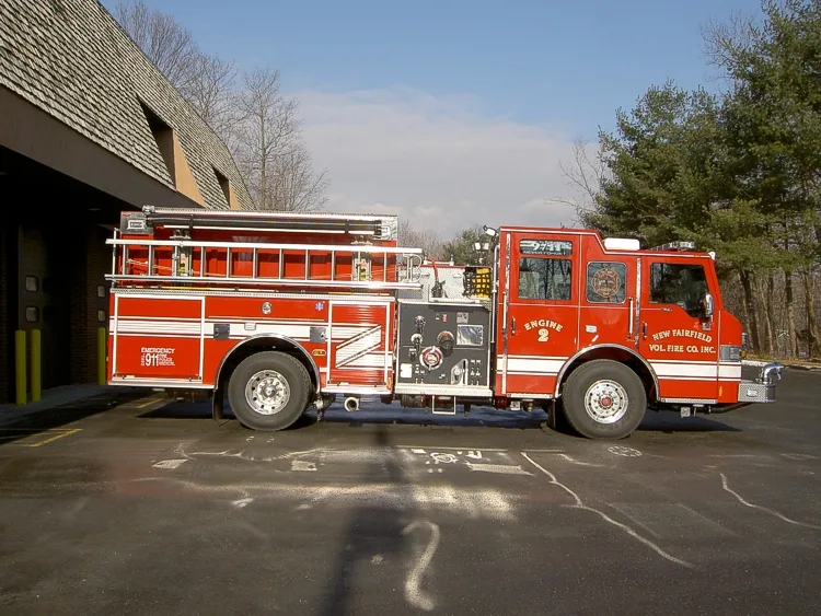 Driver-side profile showing exposed pump panel, wheel area, and side body compartments