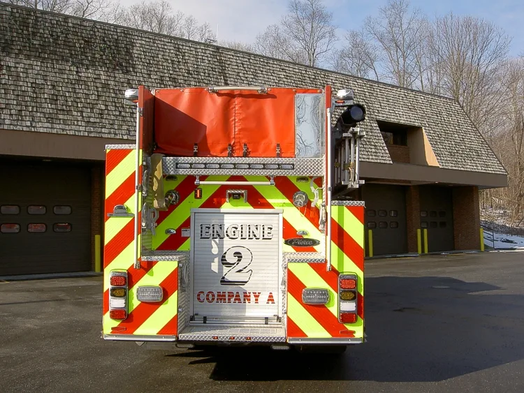 Rear view showing chevrons, hosebed opening, and rear warning lights