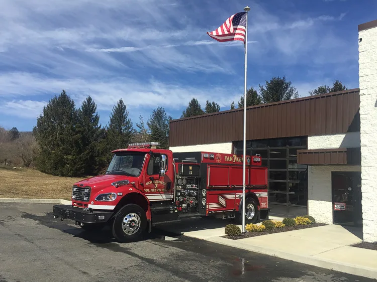 Wide scene view with the tanker parked outside showing full cab and body profile.