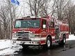 Pumper front-left exterior view in snow showing enclosed cab and side compartments
