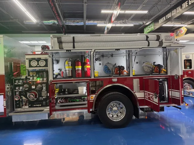 Driver-side profile with open compartments showing pump panel and tool storage