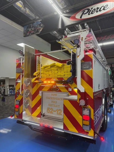 Rear view indoors showing chevron striping, hosebed opening, and rear lights