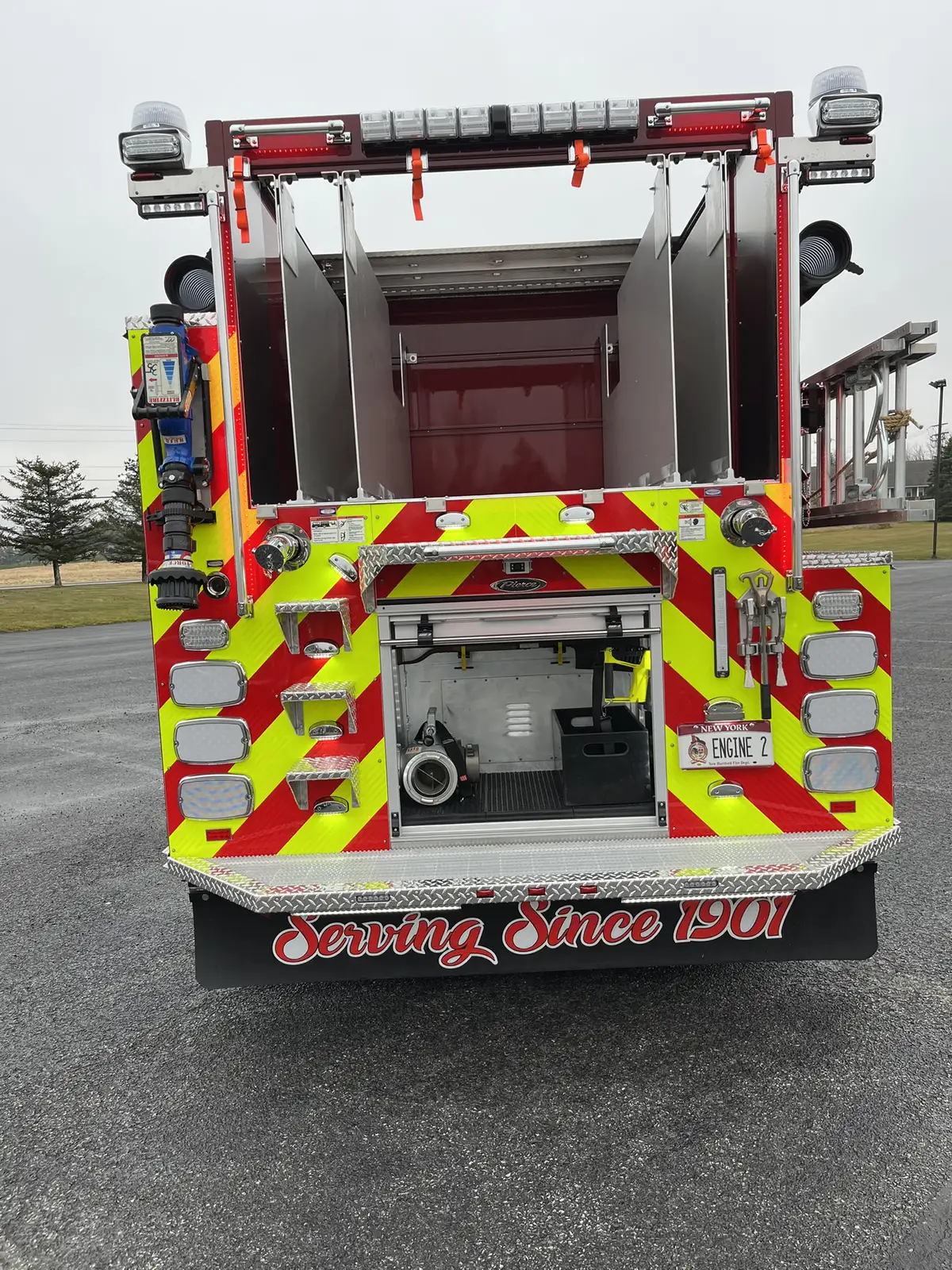 Rear view showing chevron striping, hosebed opening, and lower rear compartment
