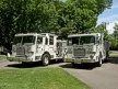 Wide front view of the two parked pumpers on a driveway.