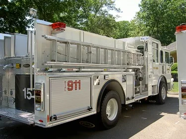 Rear right angle showing hosebed side, rear compartment doors, and wheel/tire area.