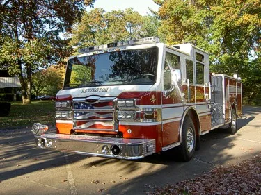 Front-left exterior view showing cab, bumper, and side body