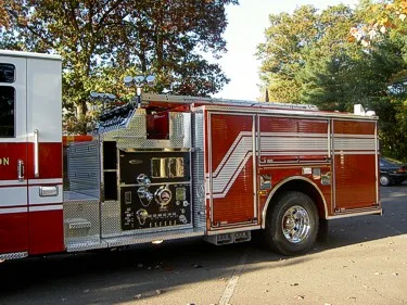 Driver-side mid-body view showing pump panel gauges and valves