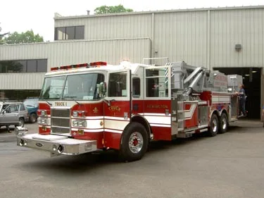 Front left angle showing cab profile, turntable section, and rear tandem wheel area.