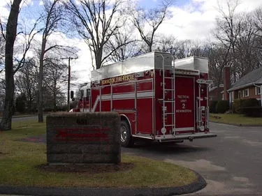 Rear right angle showing back corner ladders, rear step area, and side roll-up compartment doors.