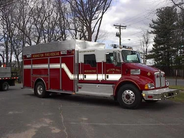Front left side view showing full apparatus length, cab doors, and side storage compartments.