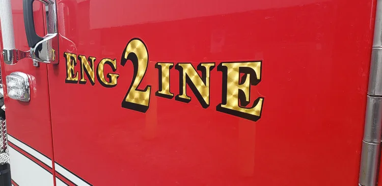 Body side close-up showing raised engine lettering on red paint