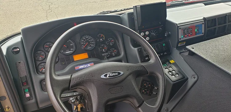 Driver cockpit view showing steering wheel, gauges, and center console